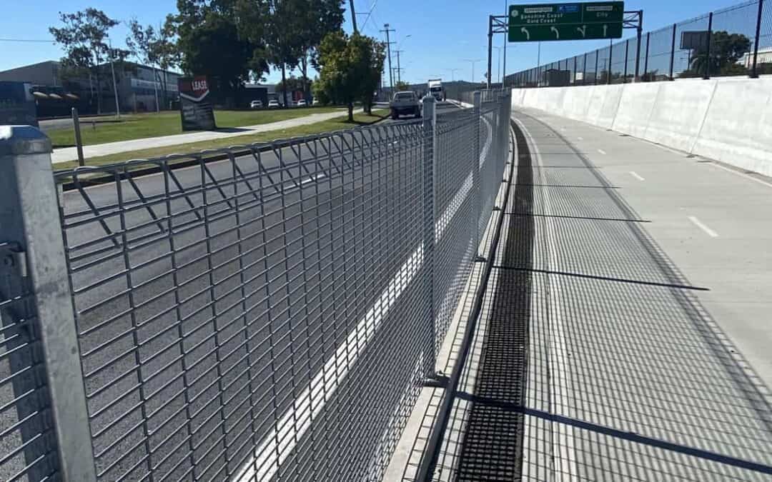 Steel mesh cycleway safety barrier fencing along commercial roadway