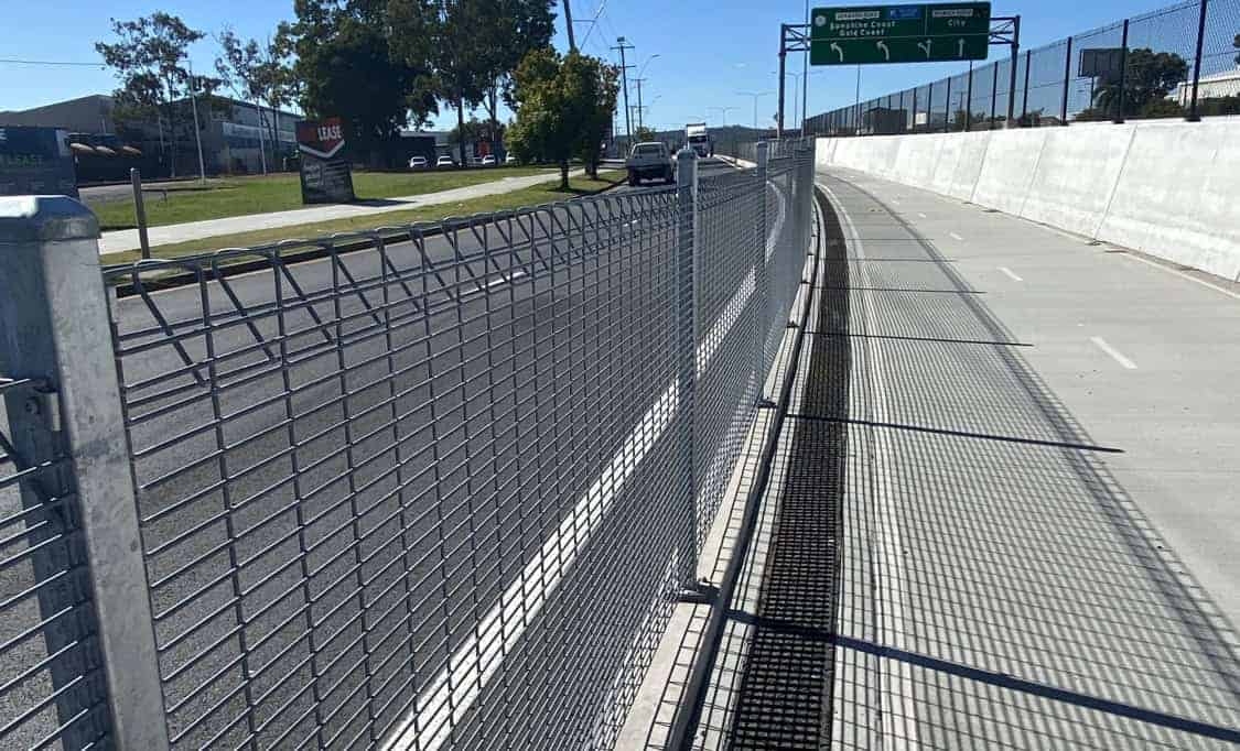 Steel mesh cycleway safety barrier fencing along commercial roadway